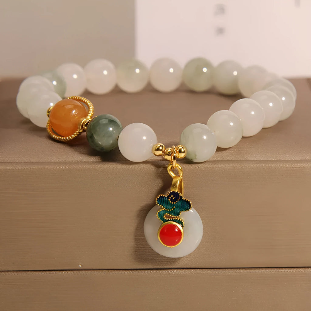 Close-up of a women's ice jade bracelet with a xiangyun peace buckle and pearl detail.