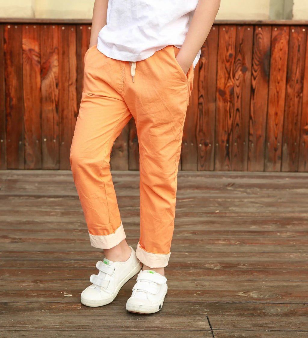 Orange cotton and linen cropped trousers for children with elastic waistband