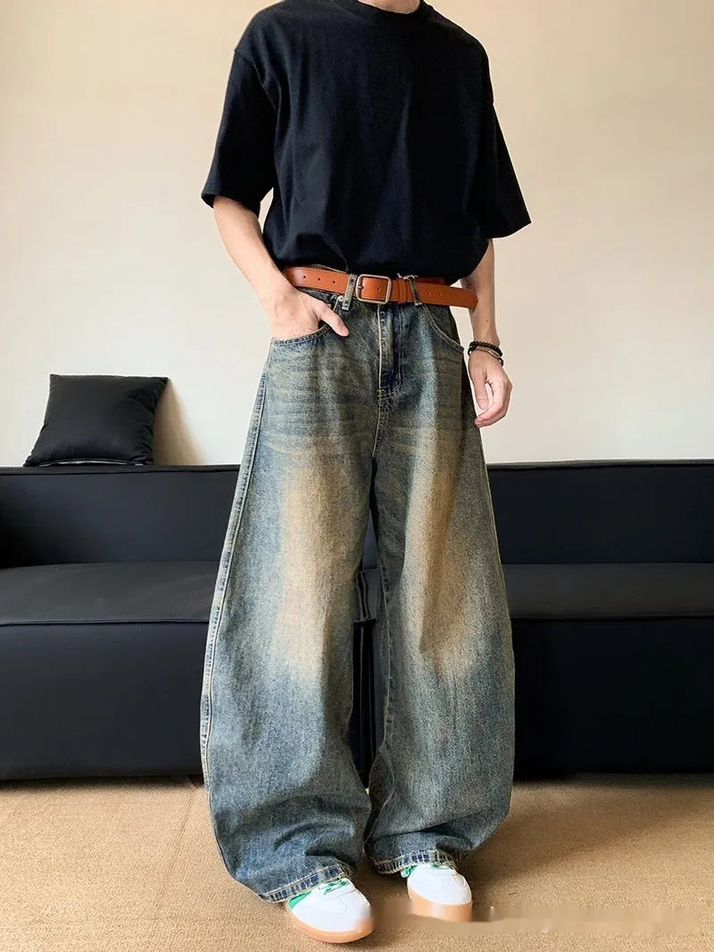 Retro blue men's distressed wide-leg jeans on a neutral background, showing machete detailing and mid-waist zip fly.
