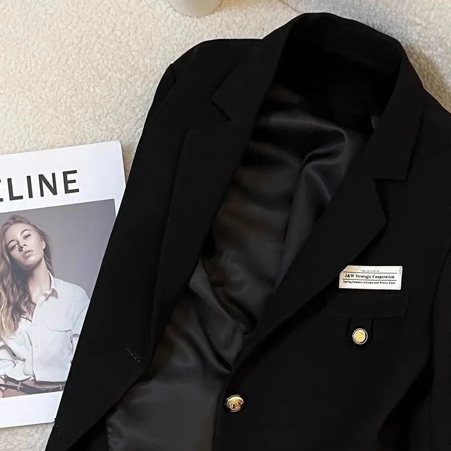 Women's black short suit coat with loose fit and regular sleeves on hanger