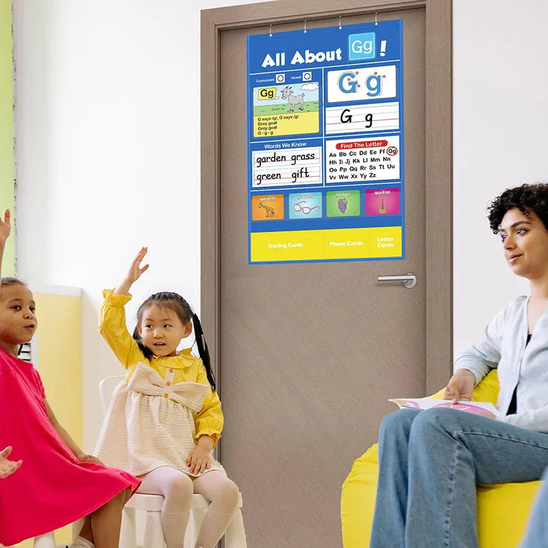 Large blue alphabet learning chart with letter cards, word cards, and picture cards arranged on its wipe-clean vinyl surface.
