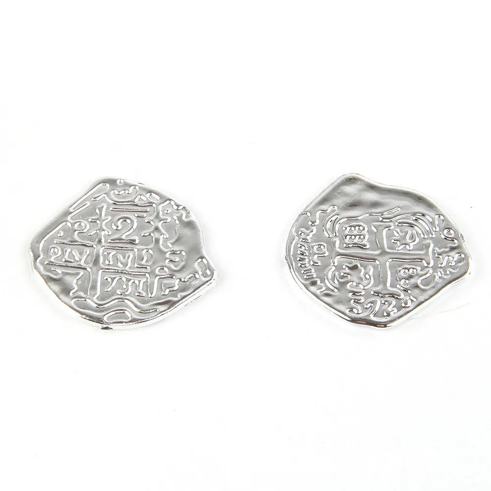 Set of 100 plastic Roman coins with electroplated bronze, gold, or silver finish, shown in hand for scale.