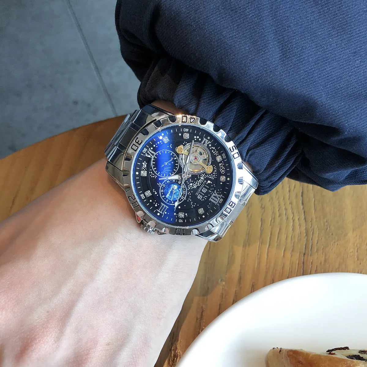 Men's silver stainless steel automatic watch with black starry dial and luminous hands on a genuine leather strap.