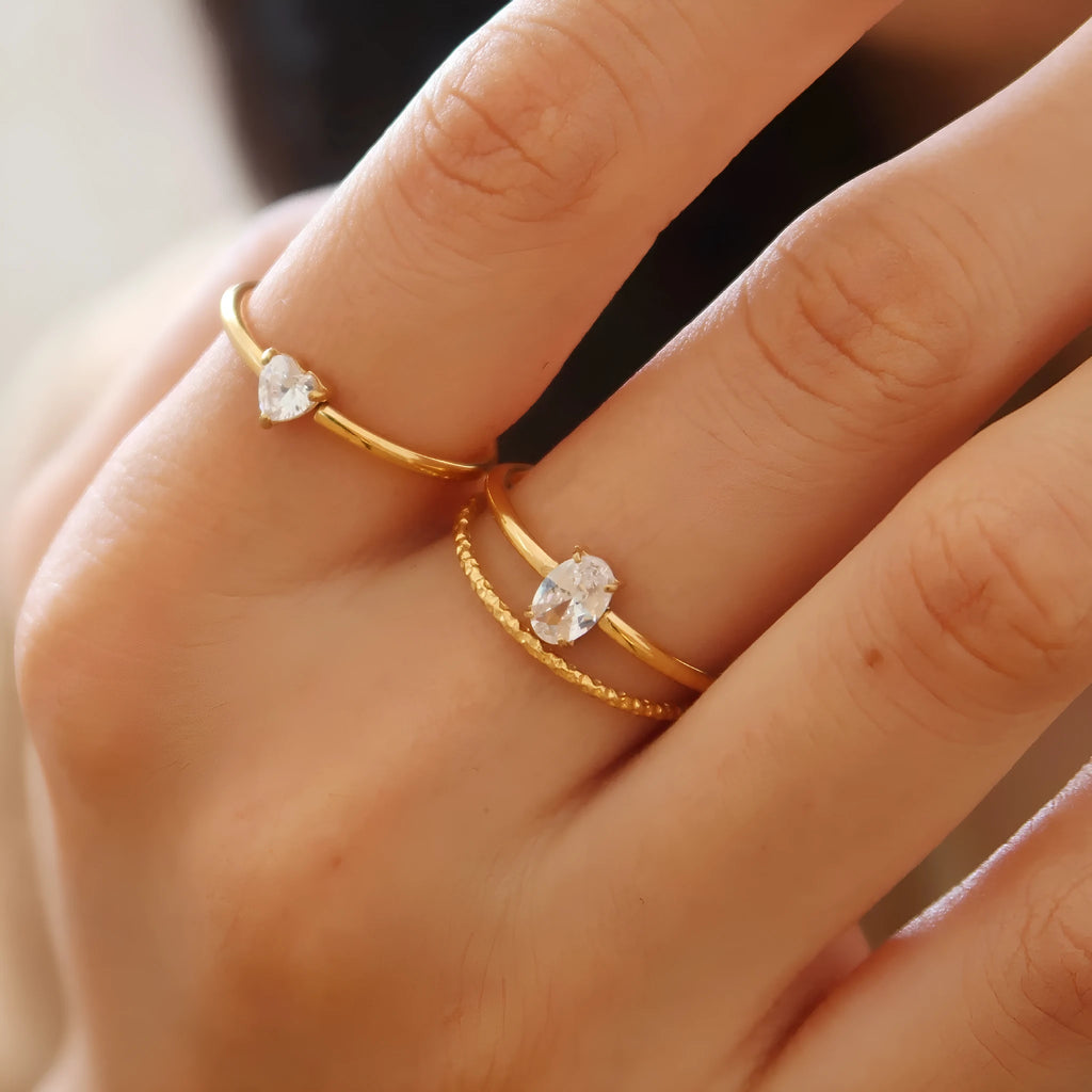 Golden heart-shaped stainless steel ring on a white background, showing its simple bracelet design and electroplated finish.