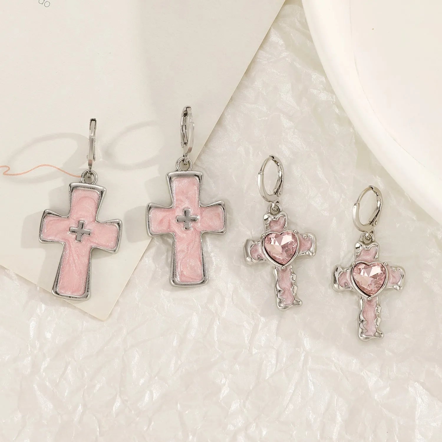 Women's alloy earrings with cross, crystal and character designs in white, black and silver colour variations