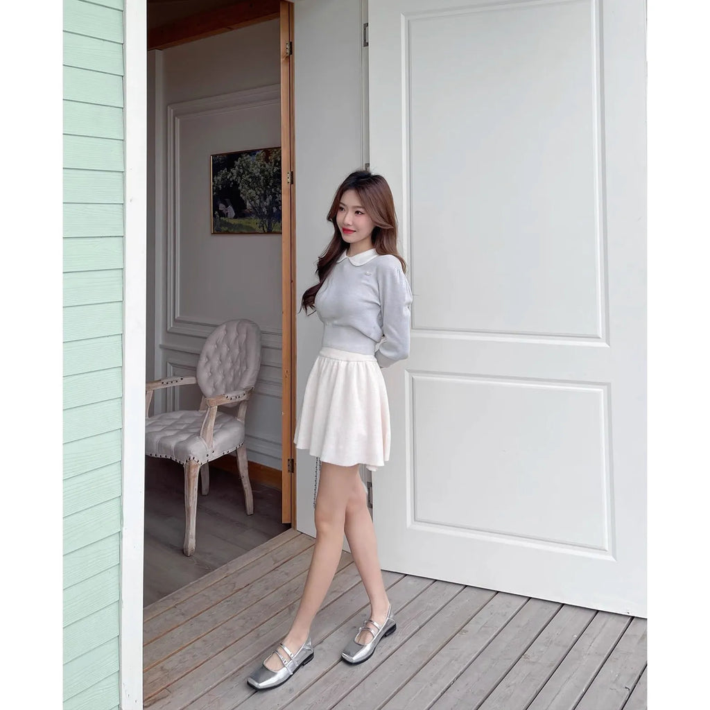 Silver women's leather Mary Jane flats with a cross buckle strap and round toe.
