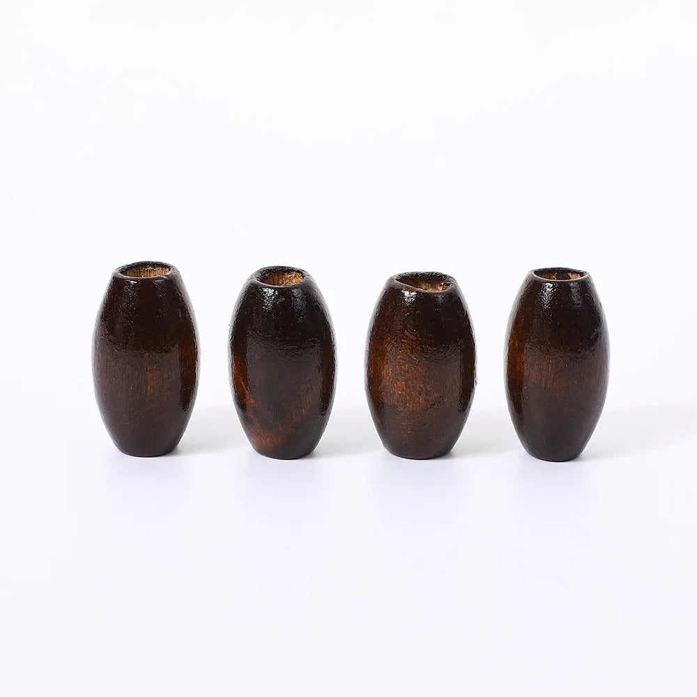 Dark coffee coloured oval wooden bead with raised M-shaped design, showing 6mm centre hole.