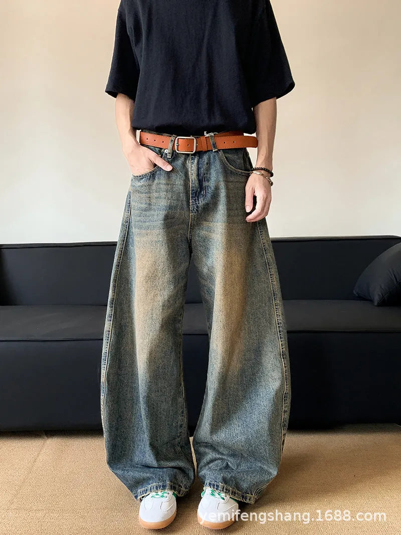 Retro blue men's distressed wide-leg jeans on a neutral background, showing machete detailing and mid-waist zip fly.