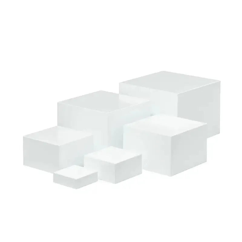 Set of six white plastic cubic dessert display stands in graduated sizes arranged in a row.
