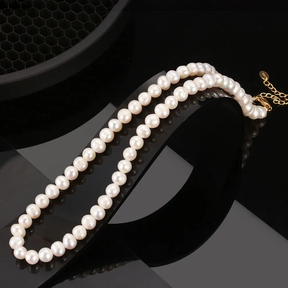 Women's silver necklace with round freshwater pearls on an adjustable chain.