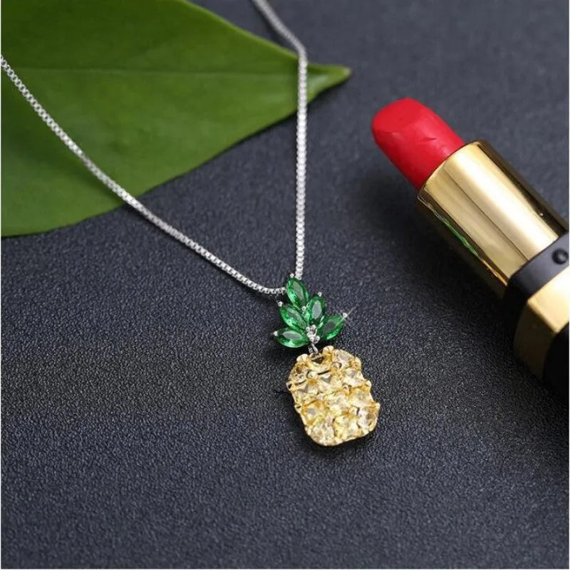 Silver geometric pineapple and diamond pendant necklace on a model.