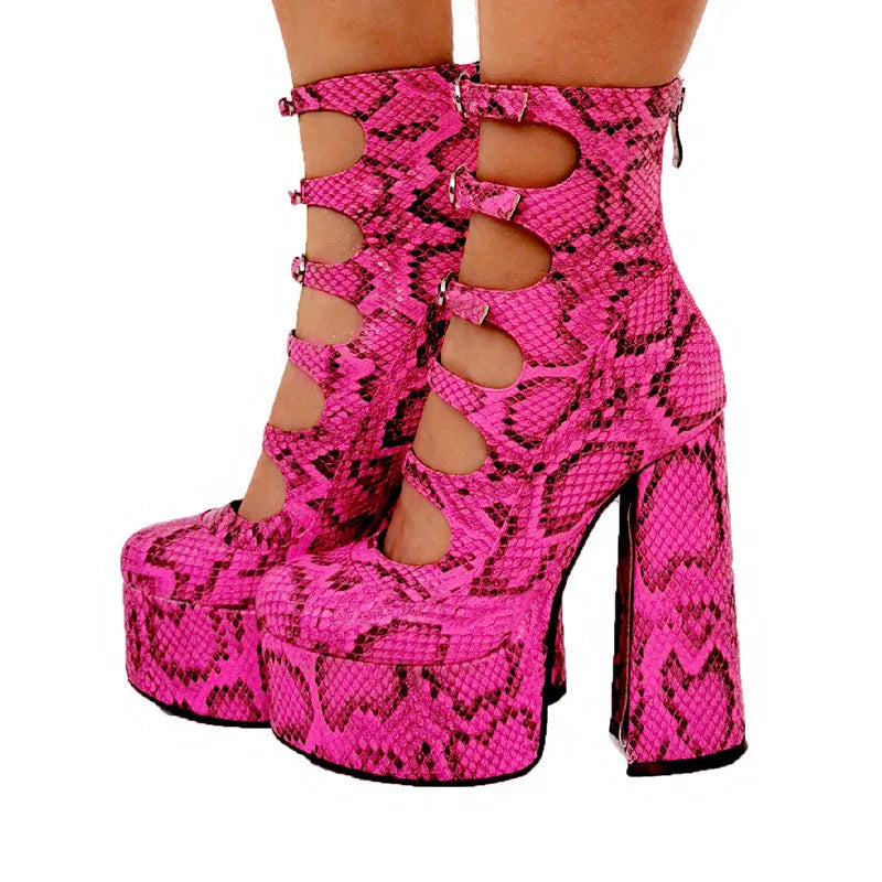Women's black patent leather platform heel ankle boots with a thick heel and serpentine belt buckle.