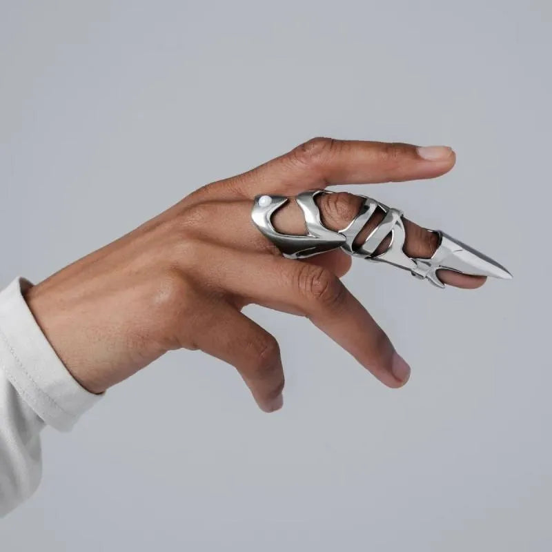 Silver alloy punk armour finger stall fashion ring on a black background.