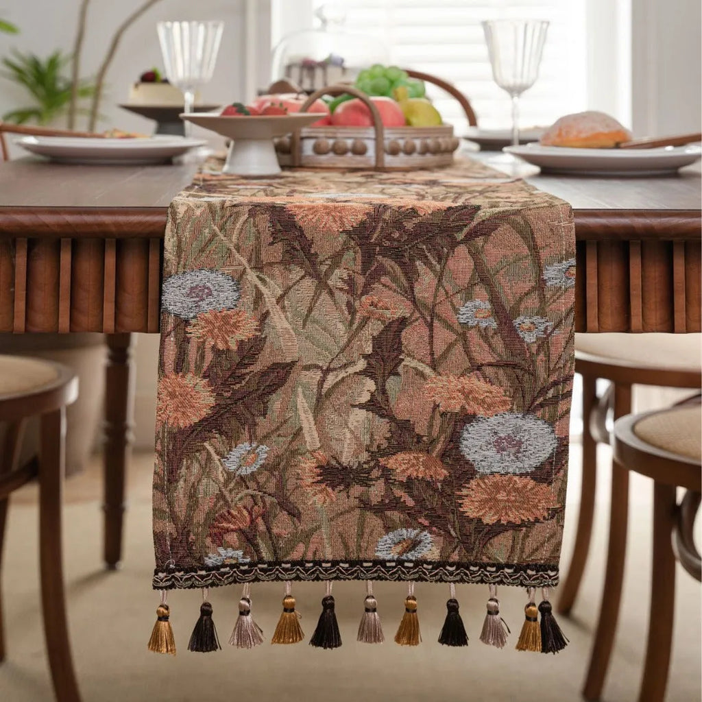 Beige jacquard table runner with long tassels and embroidered floral pattern.