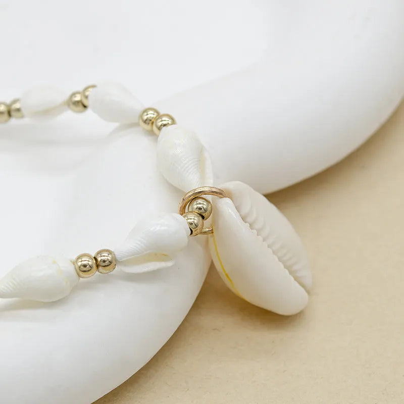 White bead necklace with conch-shaped mother of pearl shellfish pendant and regular chain