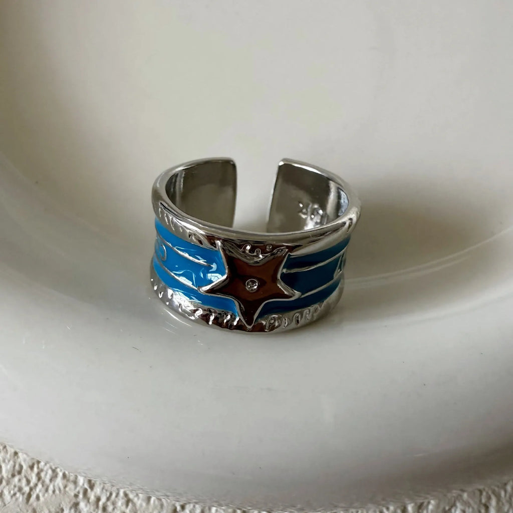 XINGX geometric drop oil ring in distressed electroplated finish on a copper base.