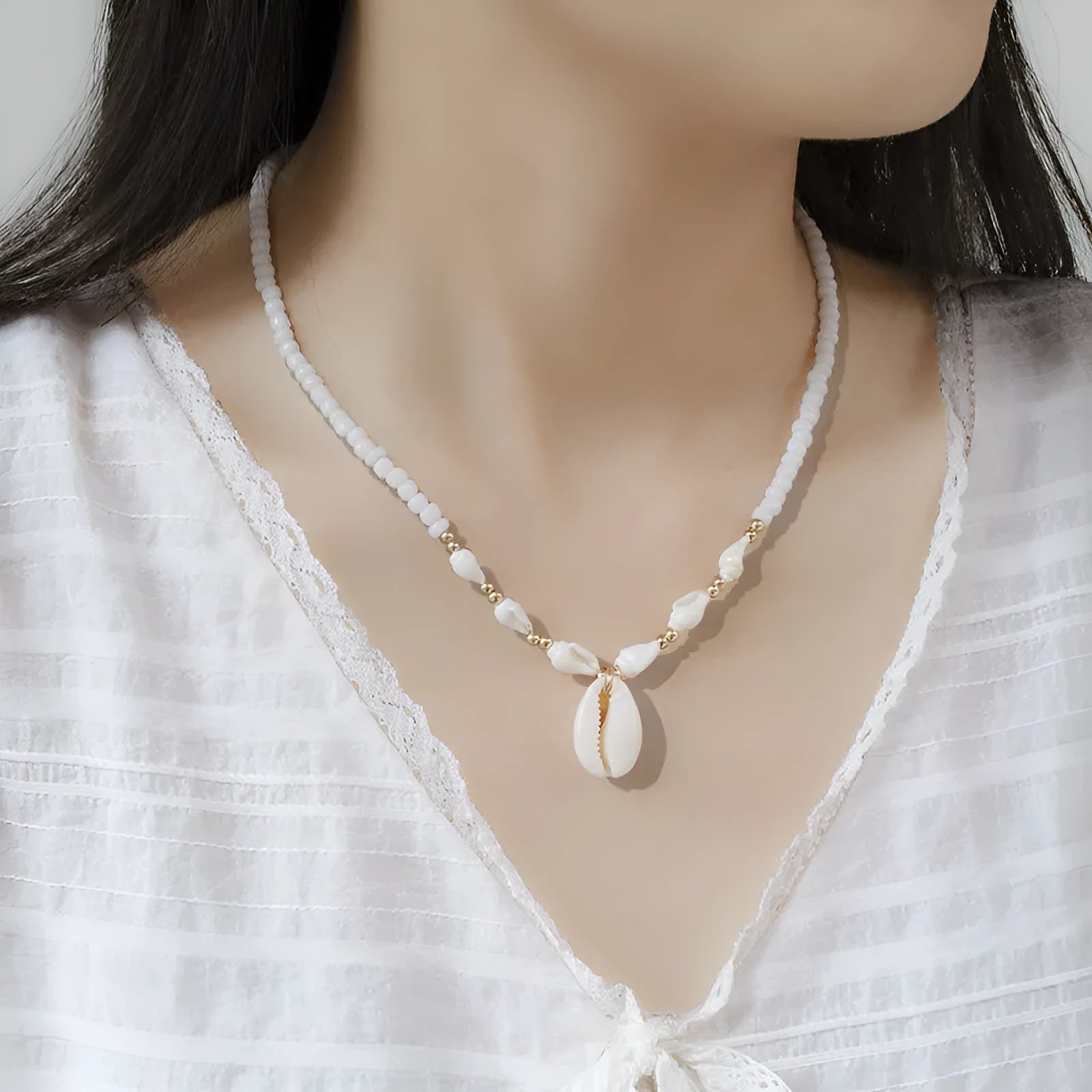 White bead necklace with conch-shaped mother of pearl shellfish pendant and regular chain