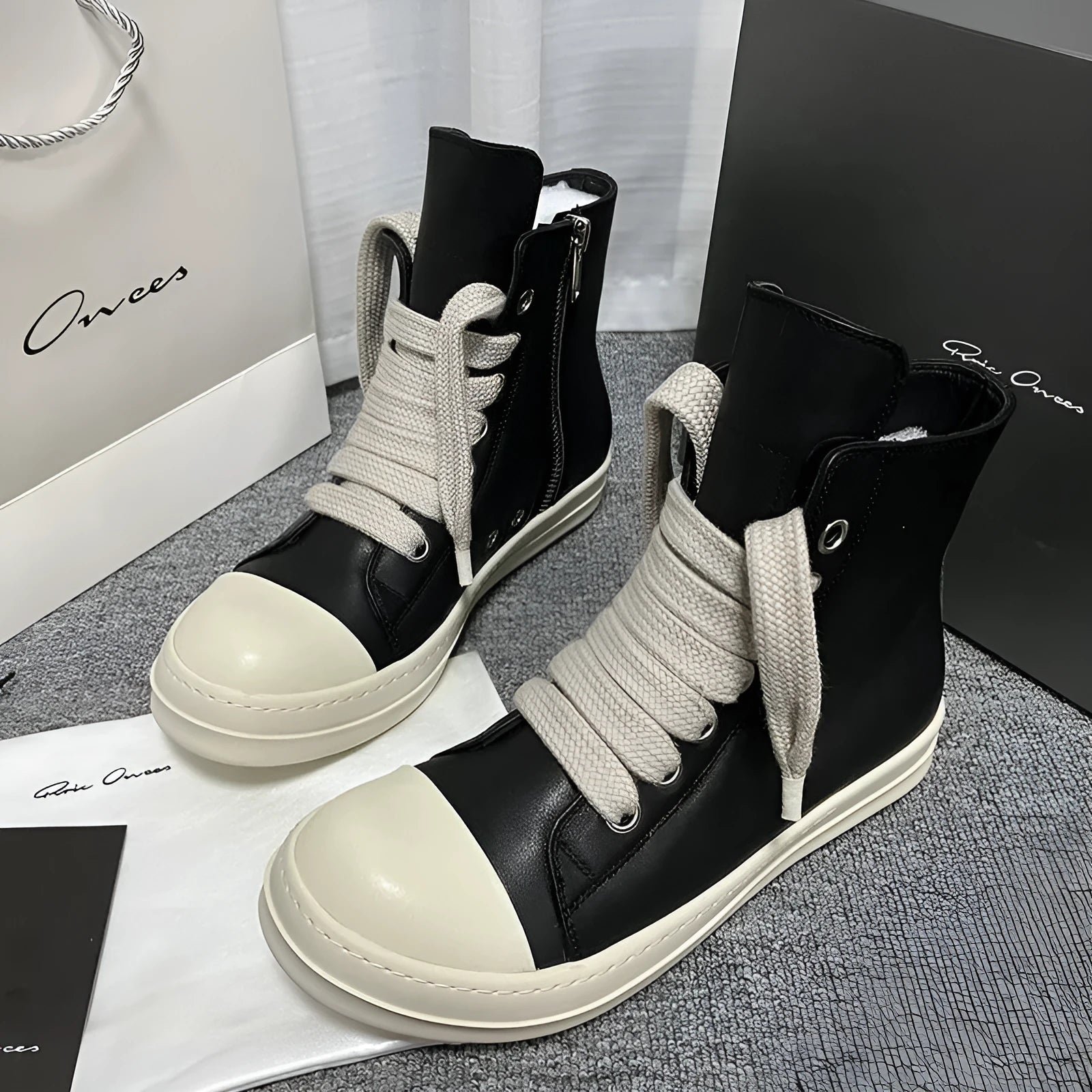Black high-top leather sneakers with side zipper on a white background