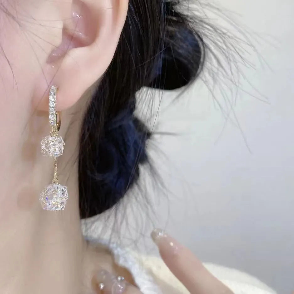 Silver women's clip-on drop earrings with a tassel ball and rhinestone ball pendant.