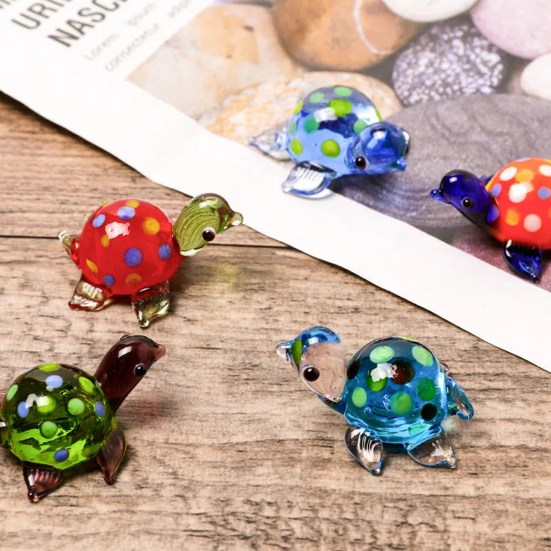 Handmade geometric glass turtle desktop ornament in a multicolour design on a wooden surface.