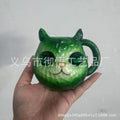 Colourful resin Crystal Earth Cat Cup craft decorative gift on a table.