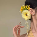 Yellow flower tassel side clip hair accessory with mixed material construction and manual processing details