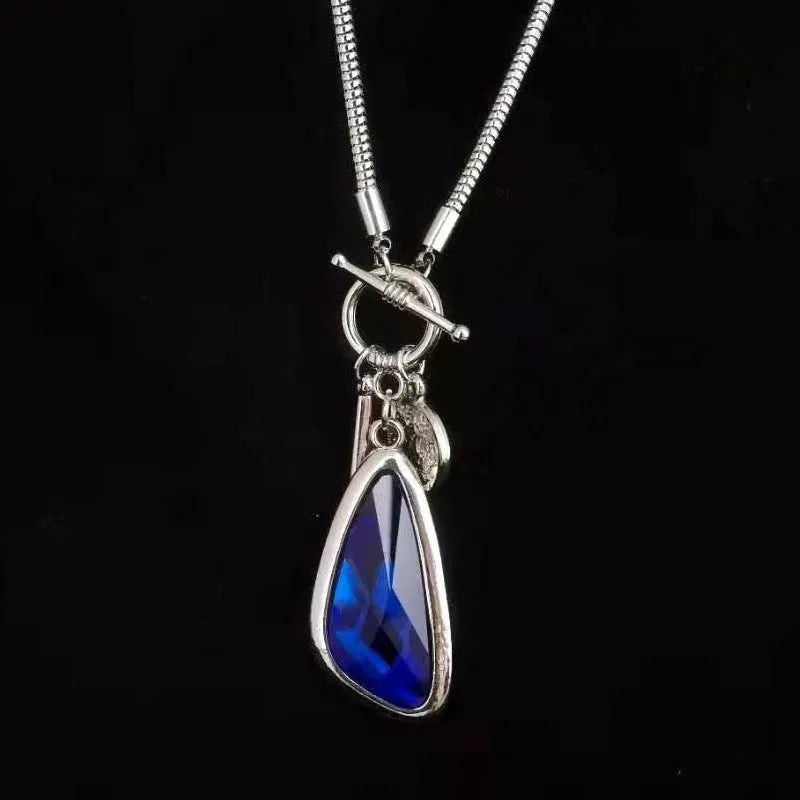 Long alloy necklace with geometric plaid pendant on snake bones chain in blue, champagne, or grey colour options.