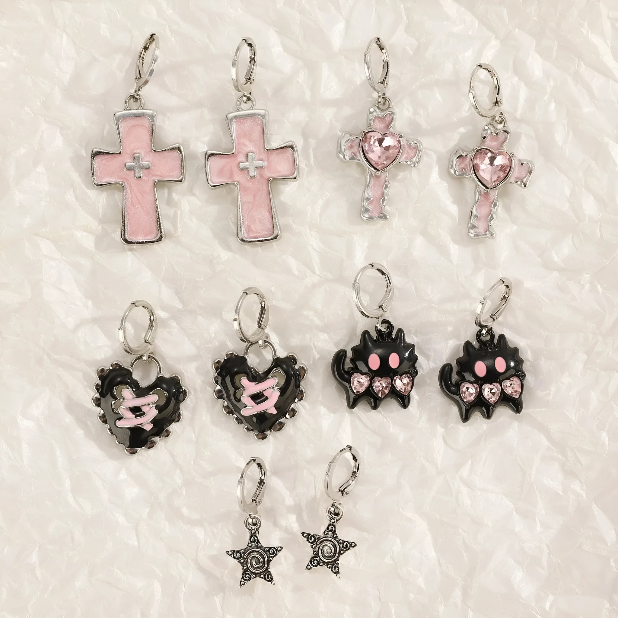 Women's alloy earrings with cross, crystal and character designs in white, black and silver colour variations