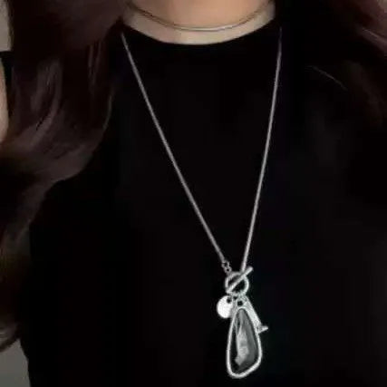 Long alloy necklace with geometric plaid pendant on snake bones chain in blue, champagne, or grey colour options.