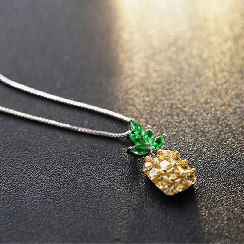 Silver geometric pineapple and diamond pendant necklace on a model.