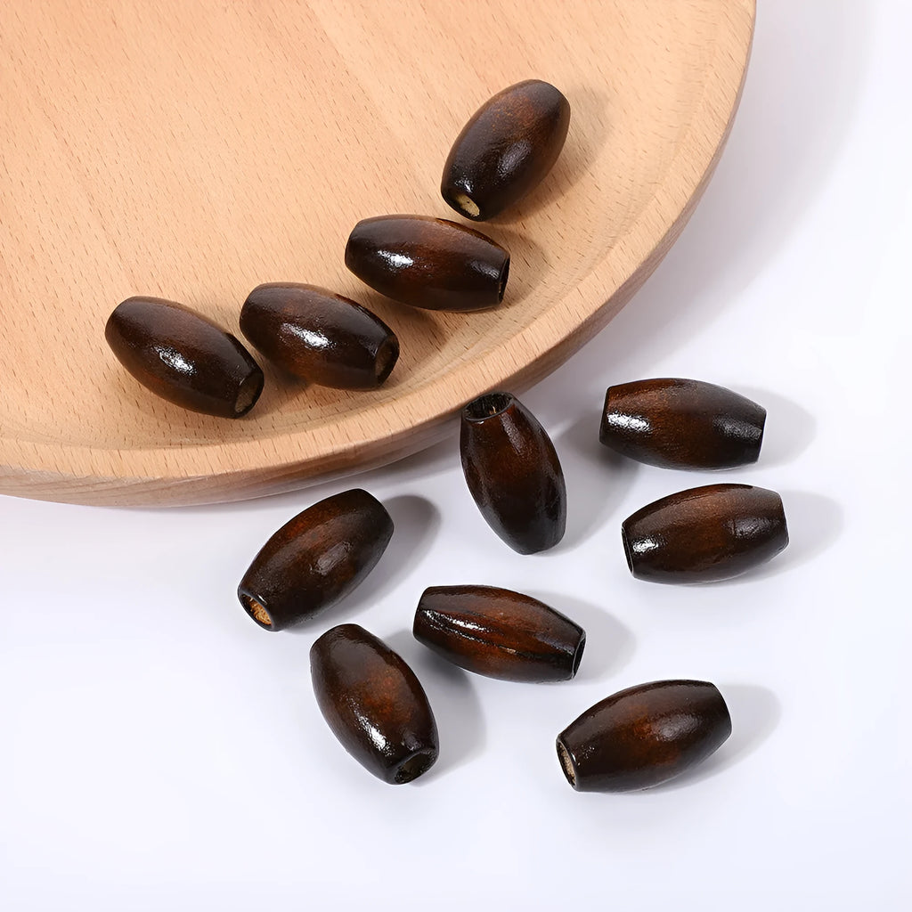 Dark coffee coloured oval wooden bead with raised M-shaped design, showing 6mm centre hole.