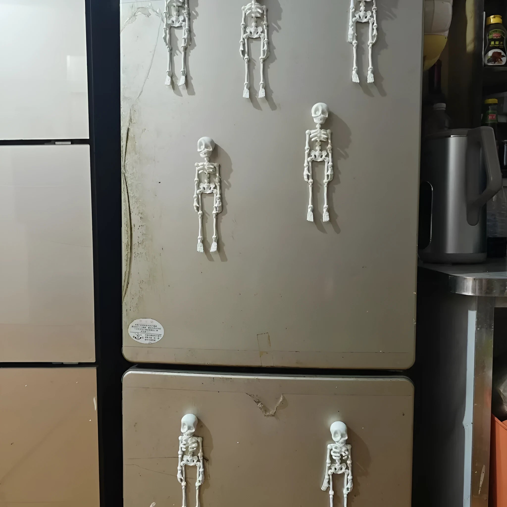 Large white 3D printed skull fridge magnet on a refrigerator door.