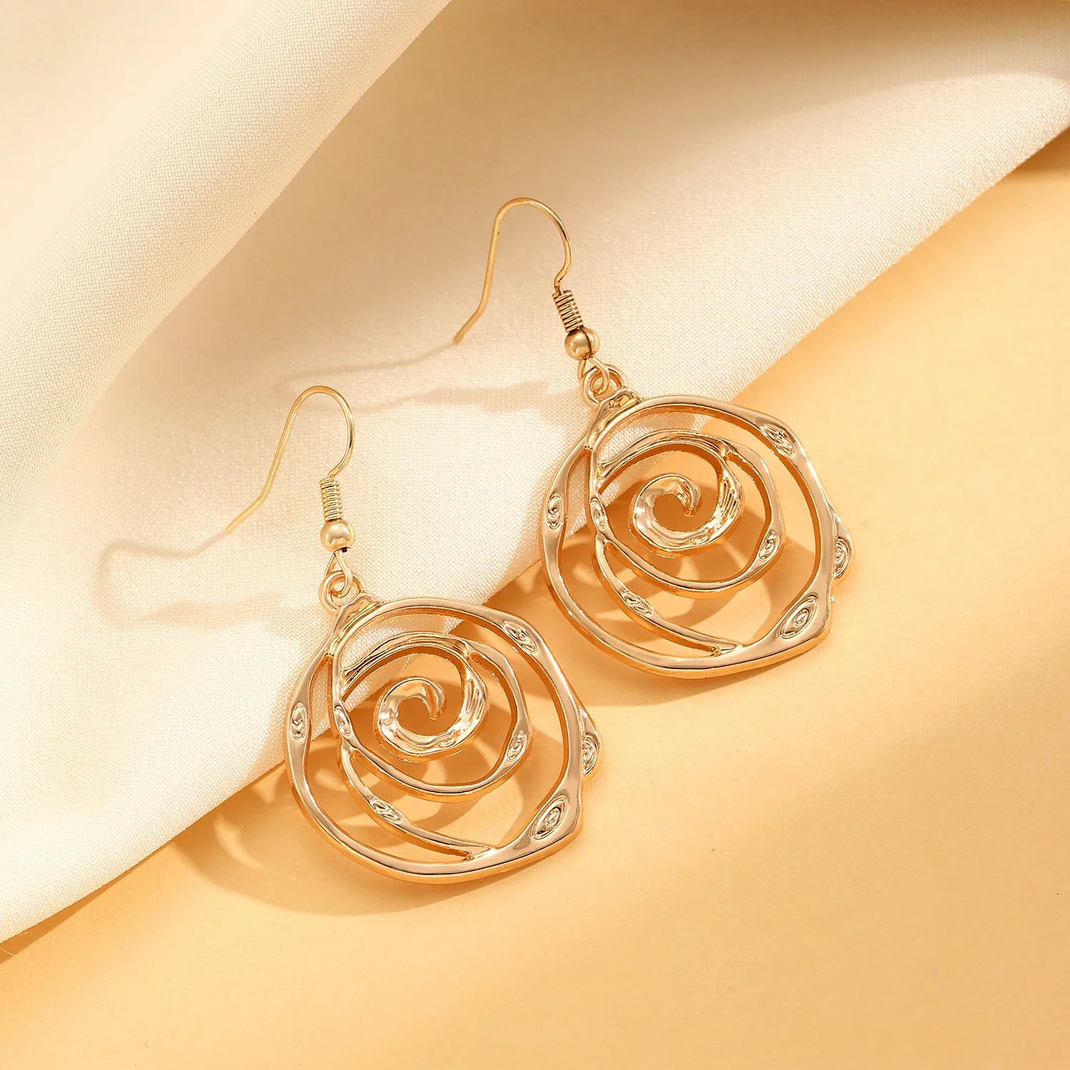 Gold spiral donut jewellery set showing necklace, bracelet and earrings with geometric circle design