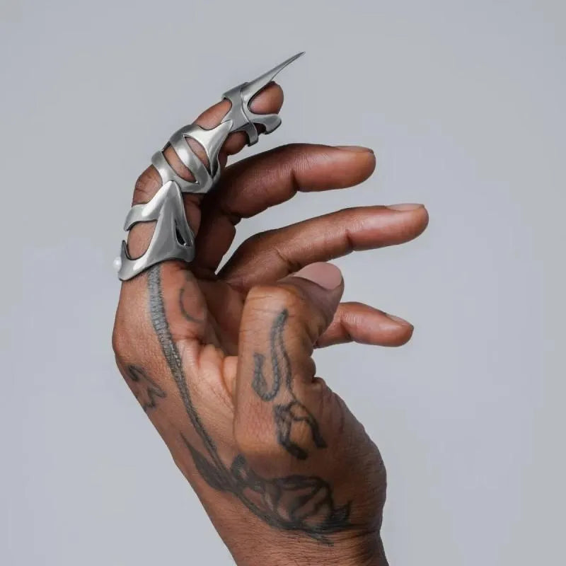 Silver alloy punk armour finger stall fashion ring on a black background.