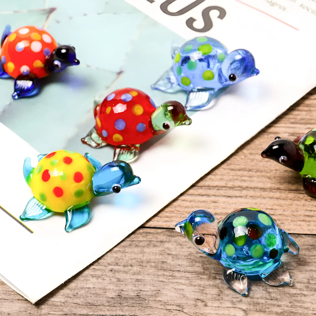 Handmade geometric glass turtle desktop ornament in a multicolour design on a wooden surface.