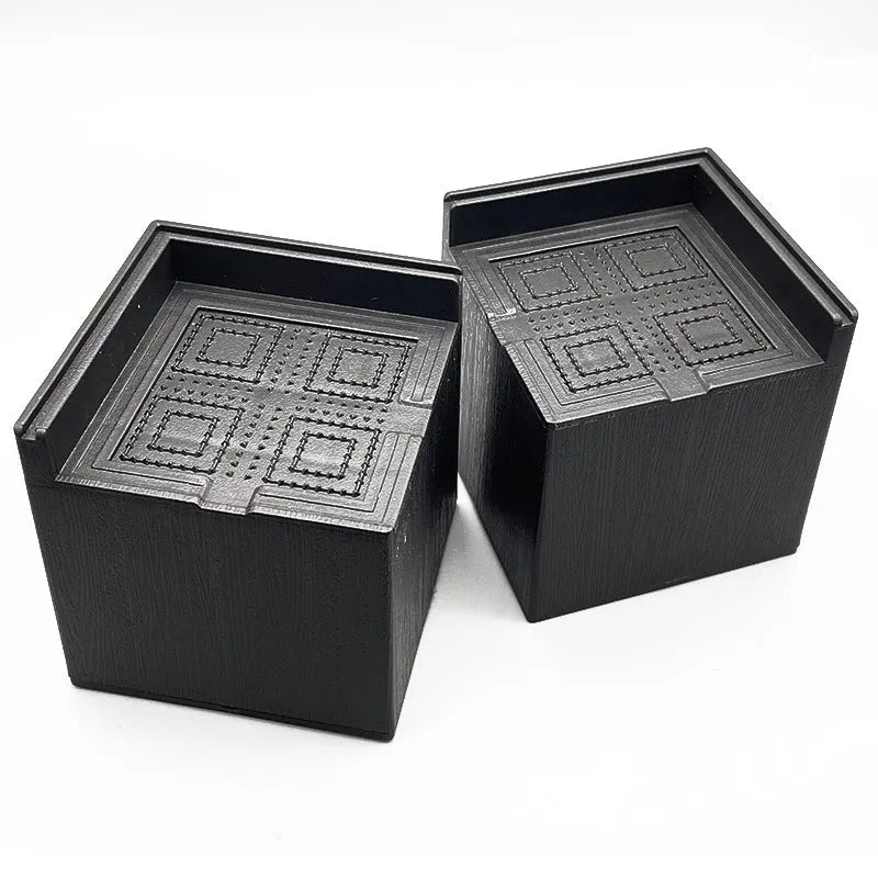 Four black plastic bed feet height adjustment mats for furniture levelling