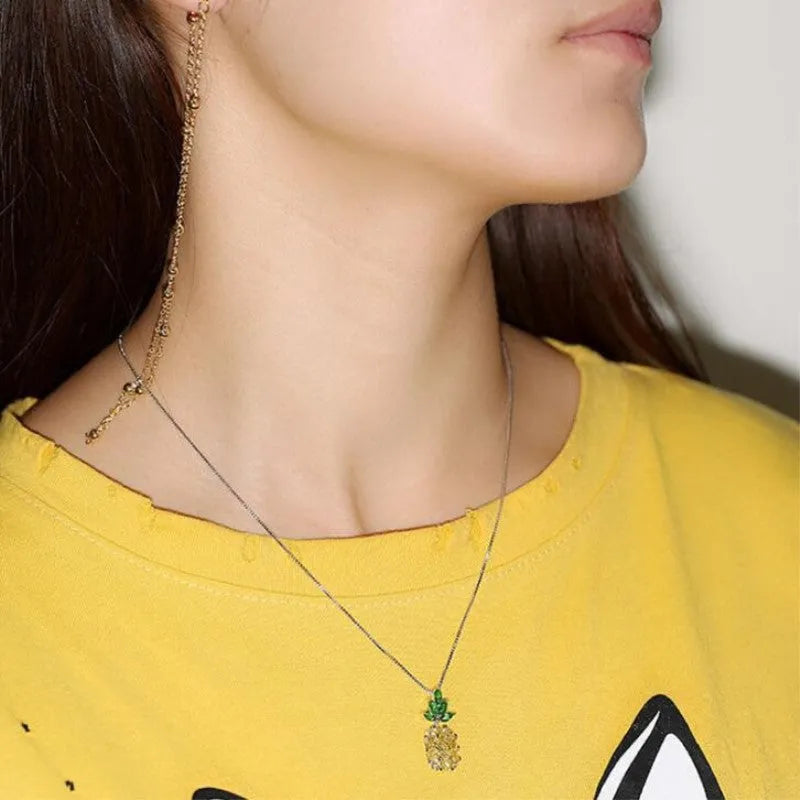 Silver geometric pineapple and diamond pendant necklace on a model.