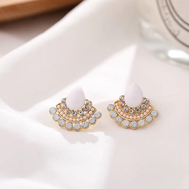 Silver fan-shaped geometric drop earrings with rhinestones on a white background.