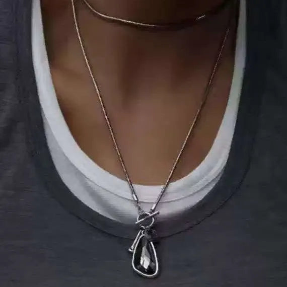 Long alloy necklace with geometric plaid pendant on snake bones chain in blue, champagne, or grey colour options.
