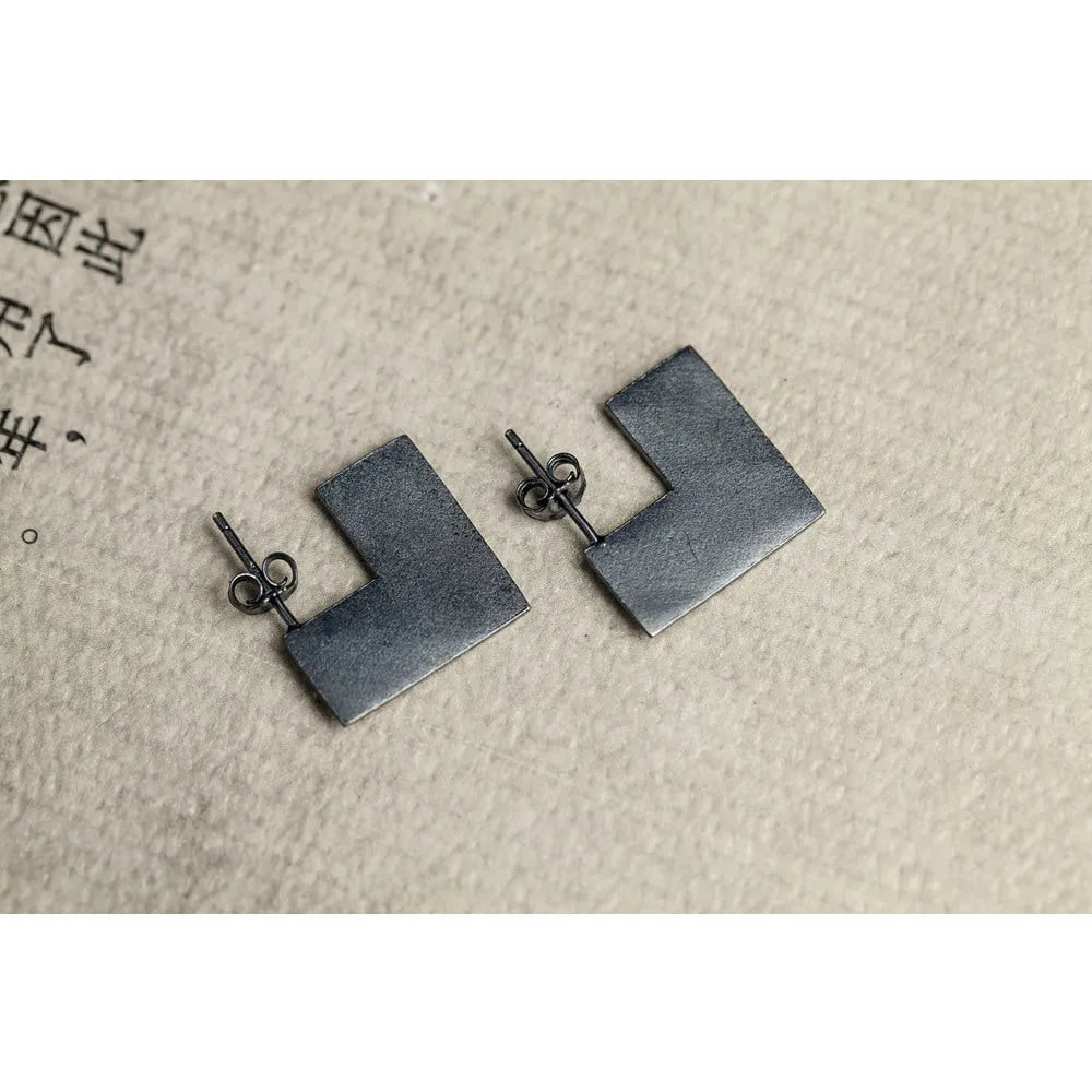 Oxidation black geometric square sterling silver earrings on a white background.