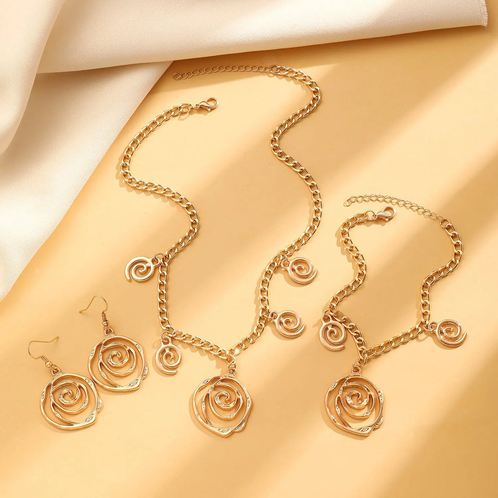 Gold spiral donut jewellery set showing necklace, bracelet and earrings with geometric circle design