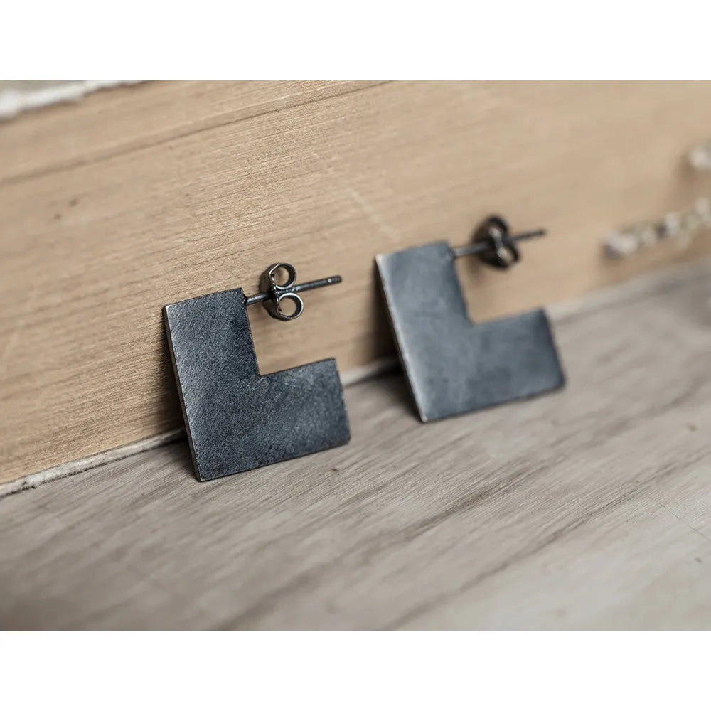 Oxidation black geometric square sterling silver earrings on a white background.