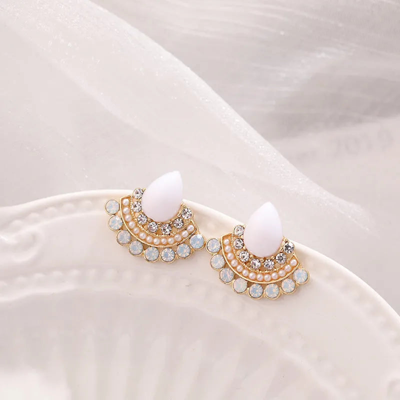 Silver fan-shaped geometric drop earrings with rhinestones on a white background.