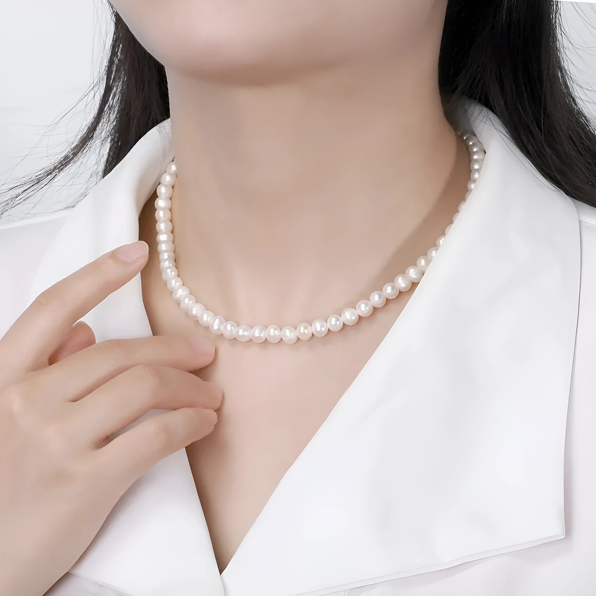 Women's silver necklace with round freshwater pearls on an adjustable chain.