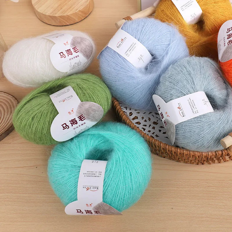 Ball of mohair wool for DIY scarf knitting kit in one of 34 colours including blue, pink, green, grey, and black.