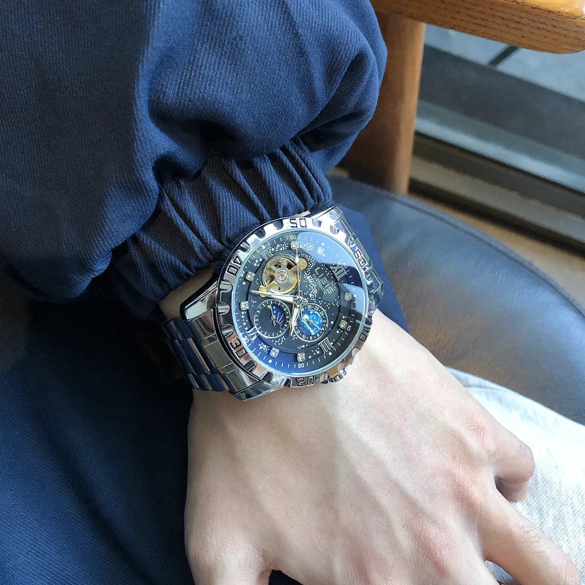 Men's silver stainless steel automatic watch with black starry dial and luminous hands on a genuine leather strap.