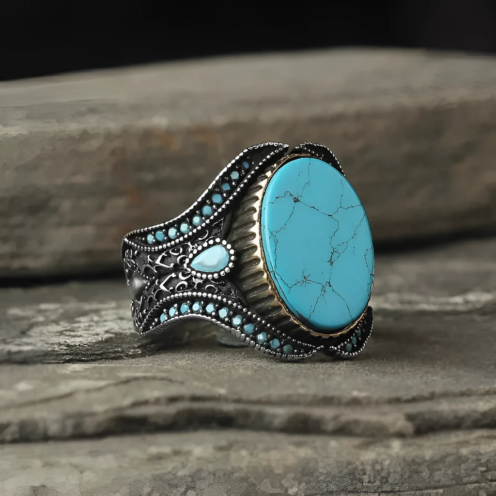 Men's antique silver alloy ring with a round turquoise-coloured stone, shown on a hand.