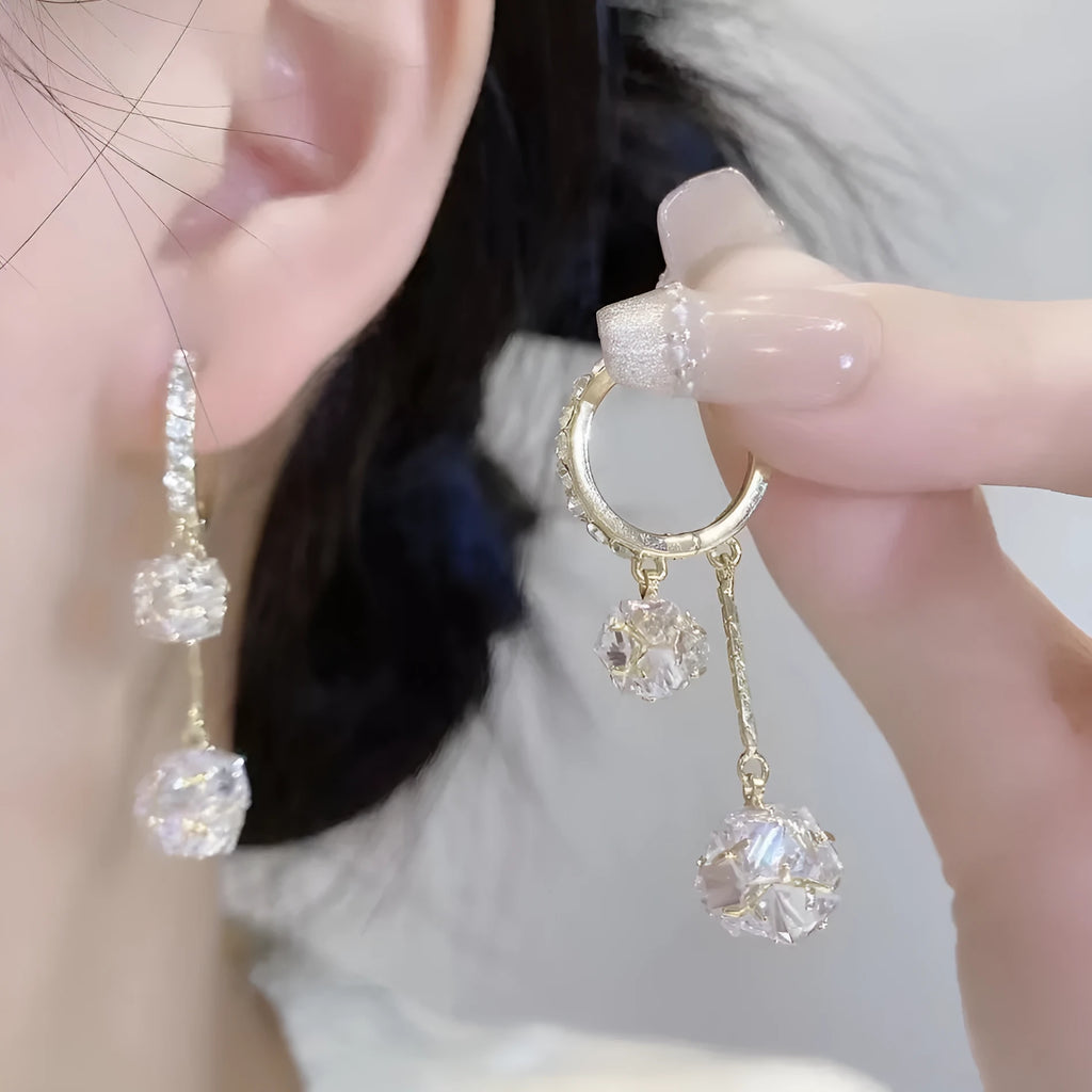 Silver women's clip-on drop earrings with a tassel ball and rhinestone ball pendant.