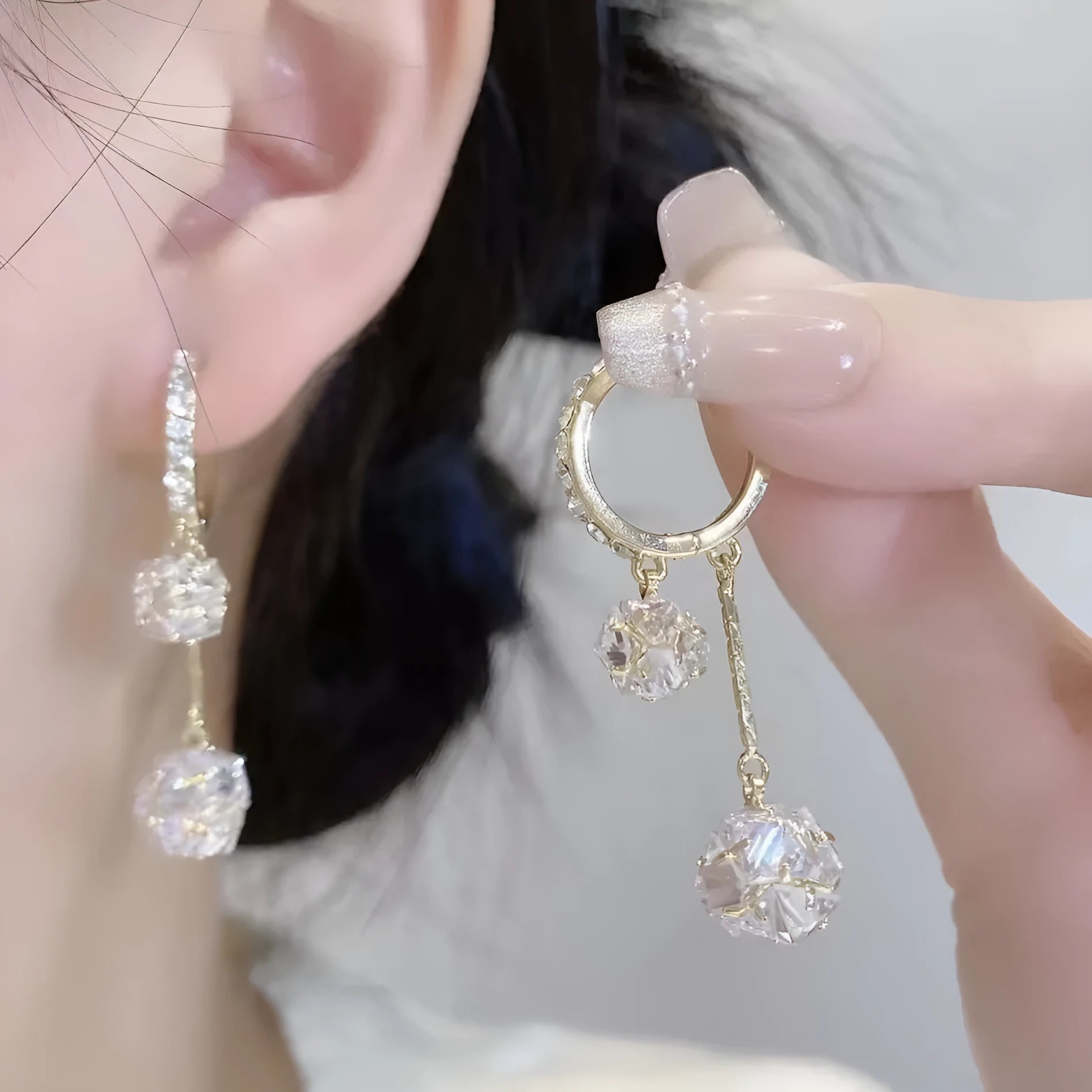 Silver women's clip-on drop earrings with a tassel ball and rhinestone ball pendant.