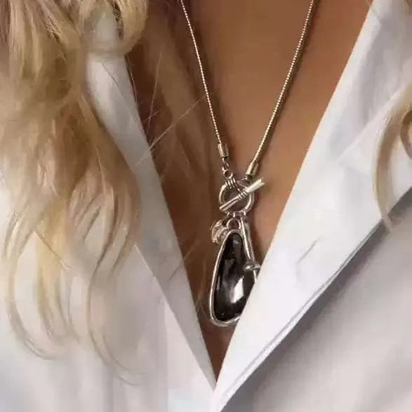 Long alloy necklace with geometric plaid pendant on snake bones chain in blue, champagne, or grey colour options.